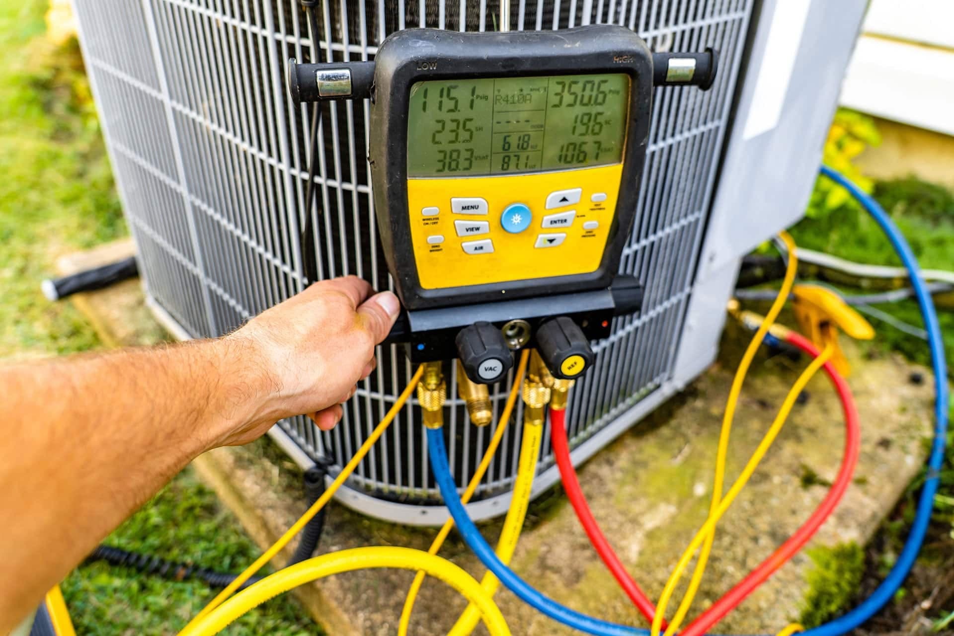 Technician using HVAC gauge on air conditioner